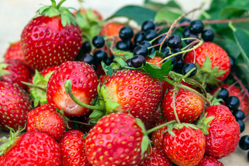 Natural organic food production. Freshly picked juicy strawberries on wooden background. Heap of summer red berries. Homegrown, gardening and agriculture consept. Backlight