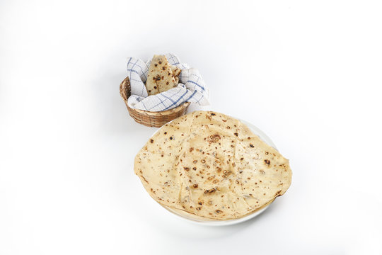 Paper thin rumali roit wheat chapati bread on white plate best served with dal tadka makhana