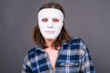 Young hipster man with long hair wearing mask