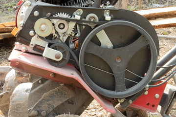 Hand tractor in the garden. A cultivator with a plow makes a furrow in the soil for a potato plantation. walk-behind tractor

