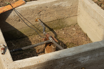 metal pipe with water and around a concrete wall
