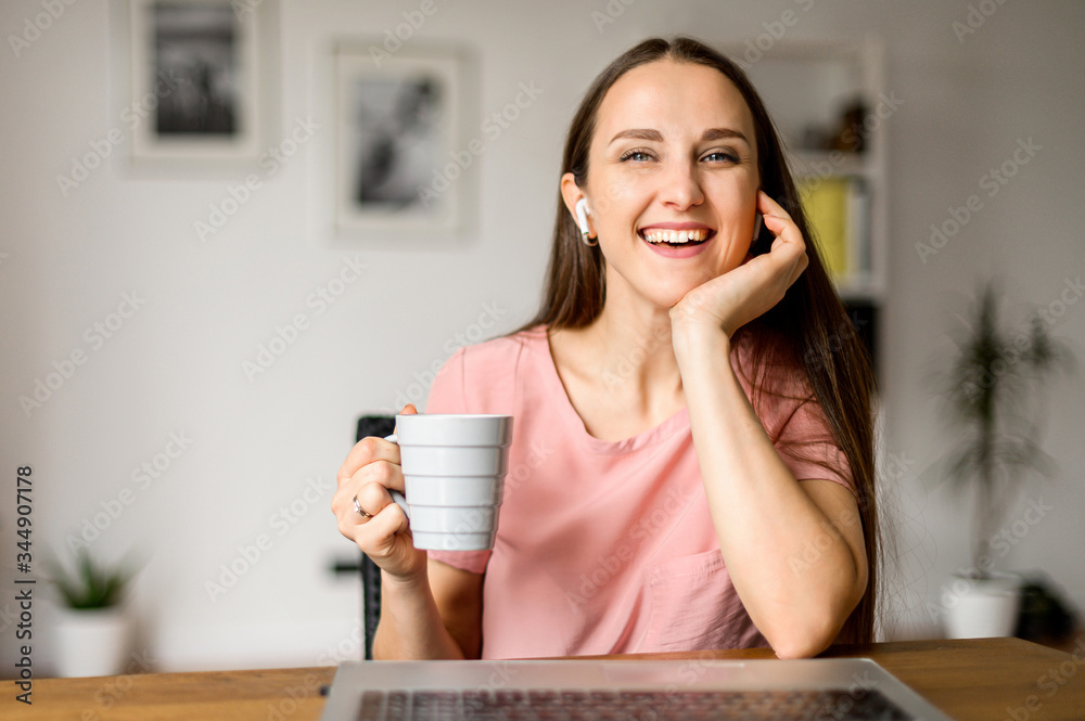 Wall mural online conversation with friend. webcam view of attractive young woman, she is smiling and looks at 