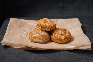 Buns from the Kraft oven, food paper and dairy products, a glass of milk.
Photo on a dark background.