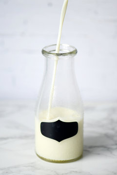 milk pouring in glass bottle