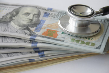 Big amount cash money with stethoscope as for health care and financial payment.