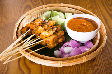 Chicken sate with delicious peanut sauce, ketupat, onion and cucumber