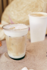 tasty coffee and frappuccino on a sand beach