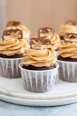 Homemade chocolate dough cupcakes with peanut butter frosting and snickers bites. Selective focus
