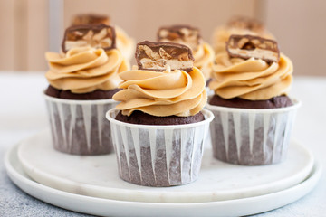 Homemade chocolate dough cupcakes with peanut butter frosting and snickers bites. Selective focus