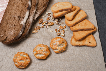 Baking, dark bread, cookies and rolls on a dark background.
Kraft paper. Milk in a transparent glass.