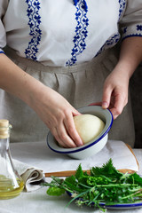Woman makes focaccia from yeast dough with various herbs. Rustic style.