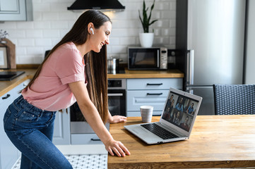 Communication on distance via video, video call, zoom. A young attractive woman using app on laptop...