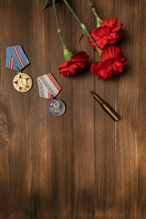 Medals and flowers on wooden table for day of glory, 9 may