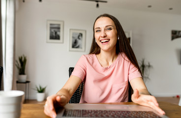 Close-up portrait of happy young woman, she looks at camera and smiling. Concept of video call,...