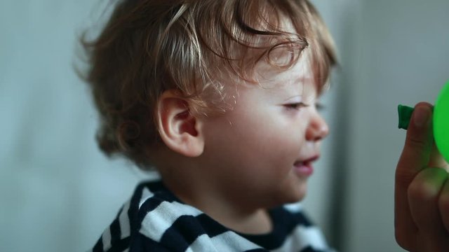 Cute baby boy turning head towards camera. Adorable sweet one year old child portrat smiling to camera
