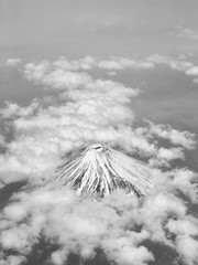 Top view of Mount Fuji covered with clouds and snow in black and white