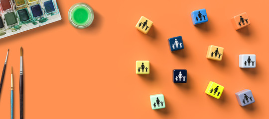 cubes with day care icons and water colors on orange background