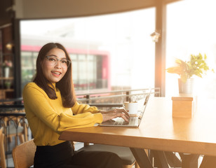 Happy young woman using laptop or notebook and having hot coffee.  Working at home, wfh with big smile during quarantine time.