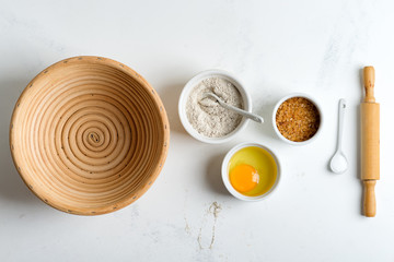 Homemade production of fresh healthy bread of other pastry from natural ingredients on a light grey background.