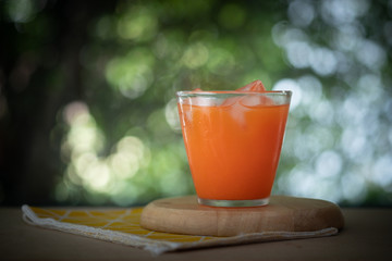 Fresh carrot juice in glass with ice