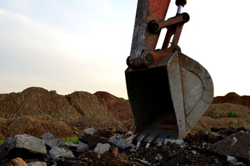 Large metal iron ladle. Excavator bucket for digging a pit and pipeline ditch at a construction site. Commercial and public civil work contracting, trenching, tamps soil. Mounting sewer storm pipes.