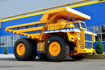 Fototapeta na wymiar Giant mining dump truck, after being discharged from the conveyor, is tested at the factory test site. Heavy-duty truck manufacture by the heavy vehicle plant.