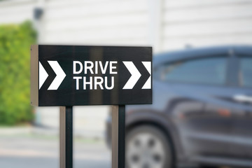 Drive thru or driving through sign with car background.