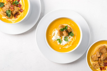 Butternut squash cream soup with milk cream, bacon, croutons, feta cheese and parsley