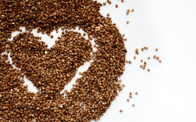 Buckwheat heart isolated on white, with place for an inscription. Heart symbol made from green buckwheat in the center. Heart made of cereals. Healthy eating