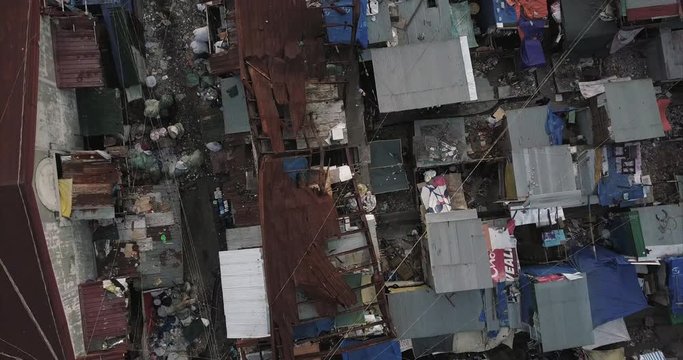Ascending rotating bird's eye view aerial flight over burned house revealing squatter area, Tondo, Manila, Philippines