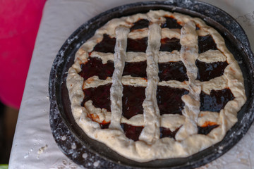 Pie with jam on a baking sheet before baking
