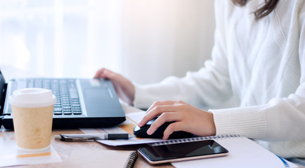 Close-up of young businesswoman using laptop and smartphone working online at home, Concept work from home