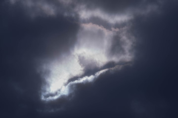 Fototapeta na wymiar Promienie słoneczne przebijające się spoza ciemnych chmur.