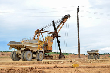 Obraz premium Big mining truck transport of minerals in the quarry. Open-cast mining of extracting rock or minerals from the earth. Largest dolomite deposit open-pit mining Gralevo, Belarus, Vitebsk region