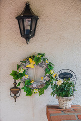 Fototapeta na wymiar Hauseingang mit Außenlampe, Blumen und Dekokranz