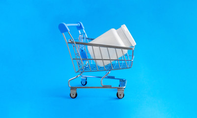 Shopping basket and medical jar with pills for the treatment of colds, flu, and viral diseases. Medical concept of purchasing medical drugs, medications or cosmetics on blue background