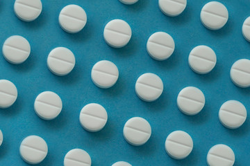 rows of pills on blue background. medicine concept or background