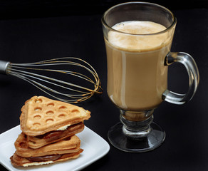 coffee latte with Viennese waffles on a black background