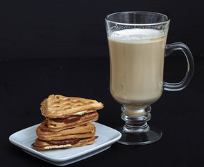 coffee latte with Viennese waffles on a black background
