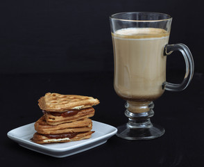coffee latte with Viennese waffles on a black background