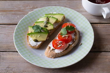 Sliced avocado  and tomato on toast bread with spices on plate