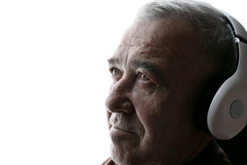 Portrait of old man in headphones listening music. White background. Free space for text.