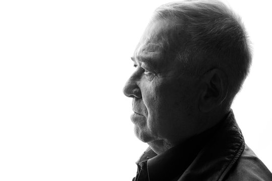 Black And White Portrait Of Old Man On White Background. Aged Male In Profile. Free Space For Text.