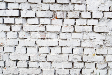 Beautiful white painted brick wall shabby old with cracks in the loft style with seams. Texture, background