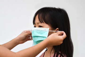 Asian little girl wear a medical mask to avoid contagious viruses. Stop the outbreak Coronavirus.