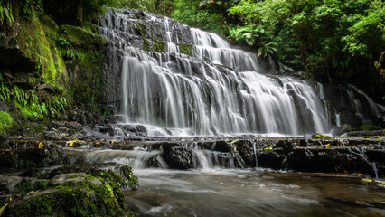 Beautiful cascade waterfall surrounded by forest. Shot made at Purakanui Falls in Catlins Forest Park, New Zealand