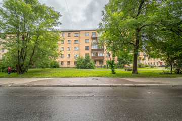 Fototapeta premium Old apartment house on green meadow in summer