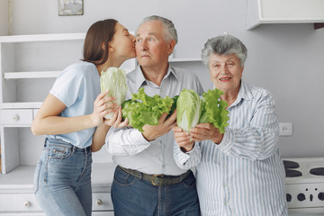Family in a kitchen. Grandparents with granddaughter. Family made a salad