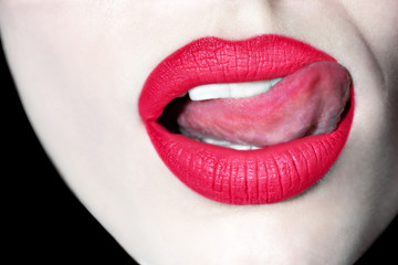 Seductive female lips. Sexy lips with tongue. Female painted lips. Pink lips. Defiant lips. Bright lipstick on the lips.