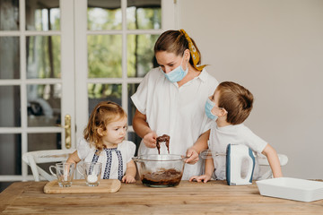 Fototapeta premium Beautiful family cooking together at home during home lock down due to coronavirus quarantine